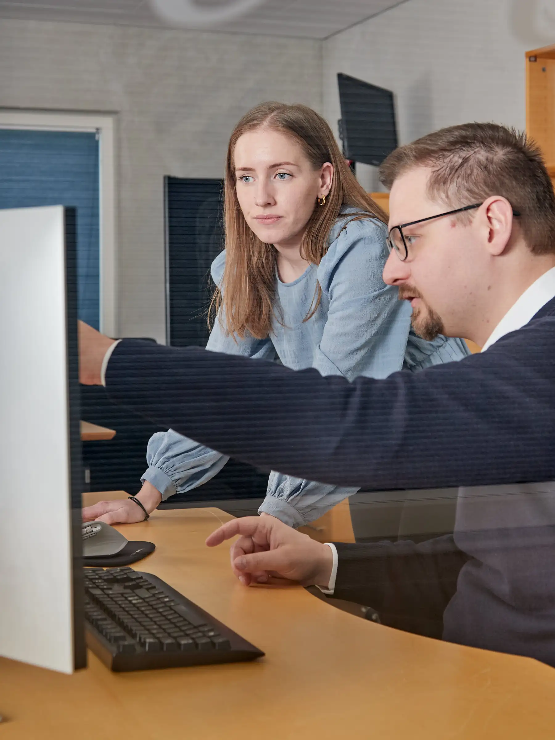 Twee kantoormedewerkers kijken naar een computerscherm