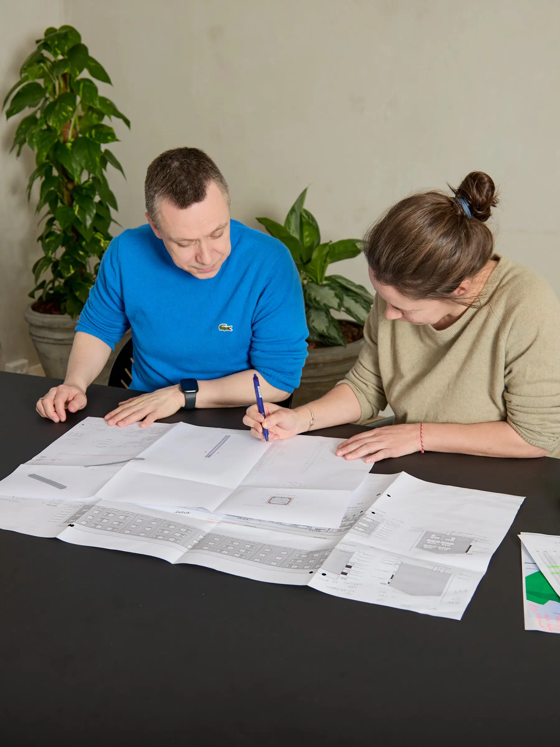 Two engineers correcting technical drawings